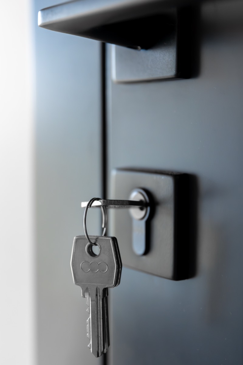 Serrure sécurisée avec clé sur une porte noire après effraction